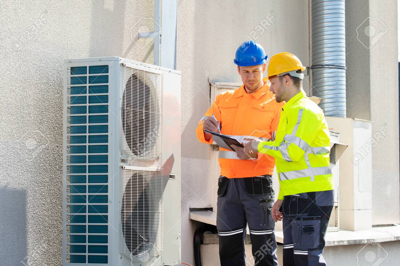 An Electrician Men Checking Air Conditioning Unit